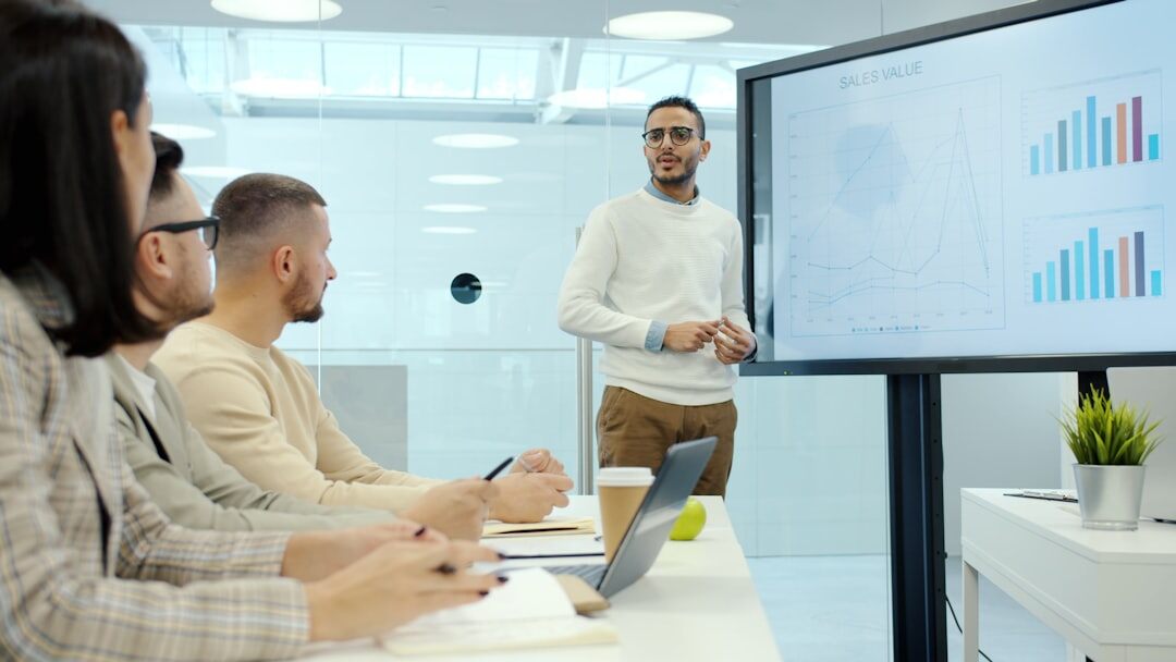 Business analyst presenting economic charts on a large screen